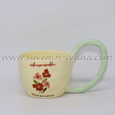 Бледожълта чаша с флорални мотиви и голяма зеленикава дръжка